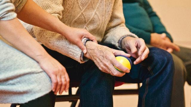 holding elderly hand hearing loss dementia