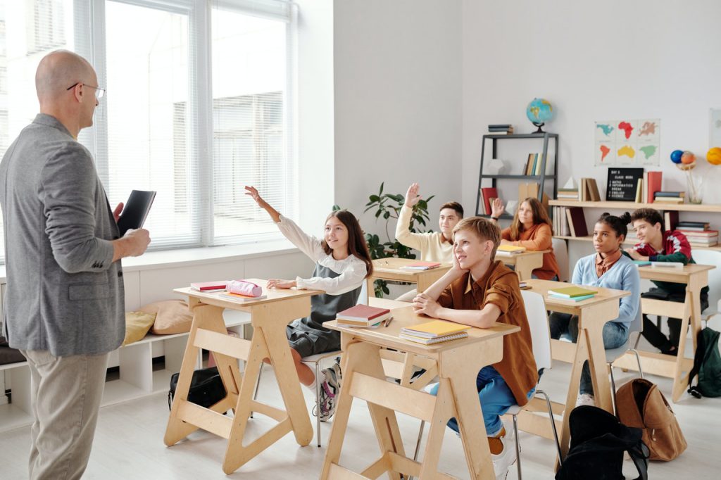 man teaching class of kids school hearing loss in children