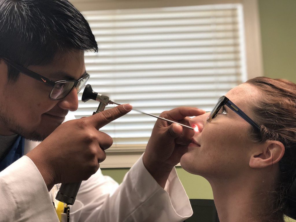 woman getting sinus checked sinus infection clogged ears from cold