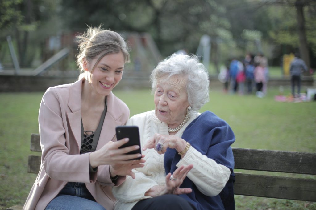 woman and older woman using phone presbycusis