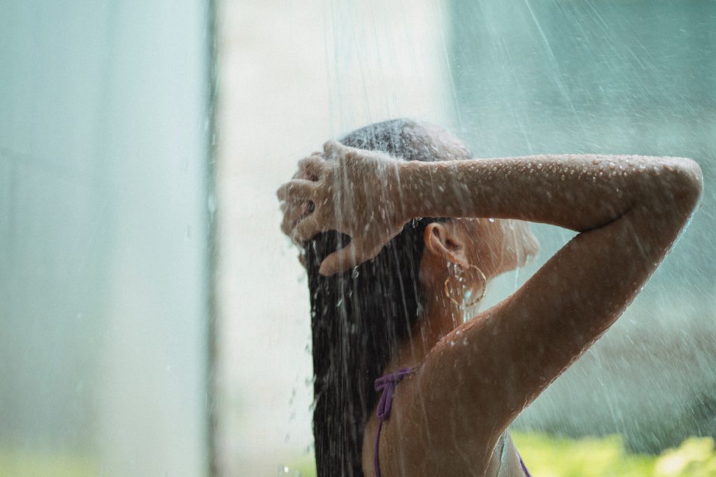 woman showering warm shower clogged ears remedy