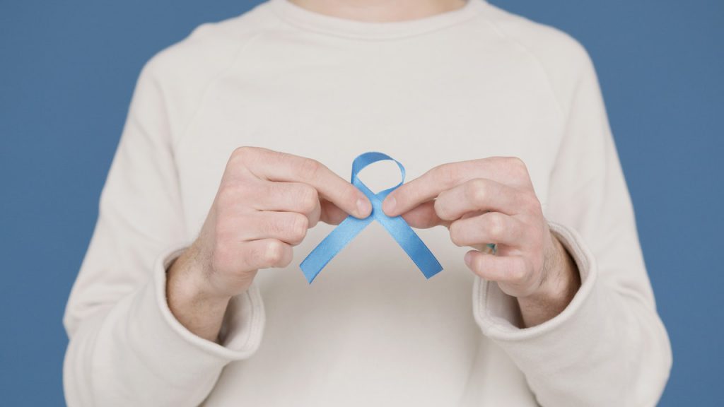holding blue ribbon donate hearing aids
