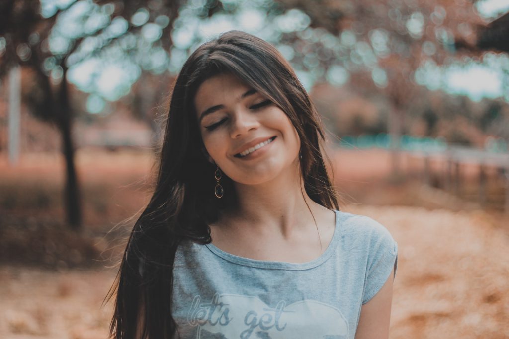 happy woman smiling listening do hearing aids help how do hearing aids work